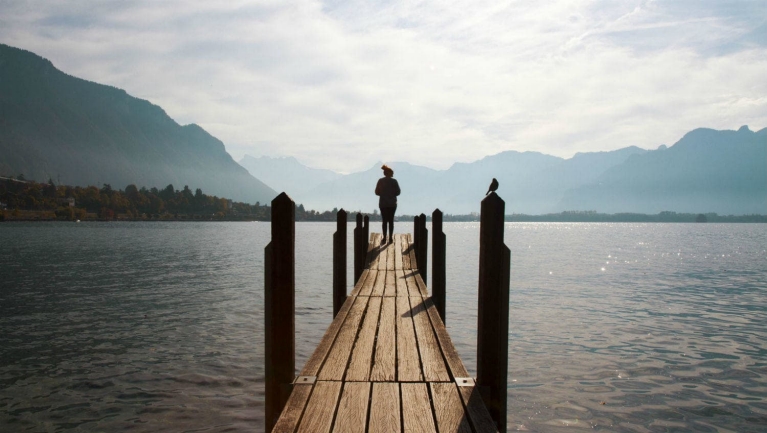 example_interrail_trip_-_girl_standing_on_a_wooden_platform_at_the_lake_geneva_switzerland_5